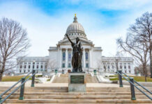 Capitol building with statue in foreground.