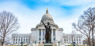 Capitol building with statue in foreground.