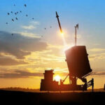 Missile launching at sunset with birds flying nearby.