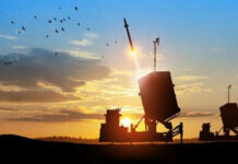 Missile launching at sunset with birds flying nearby.