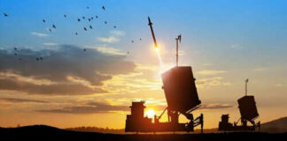 Missile launching at sunset with birds flying nearby.