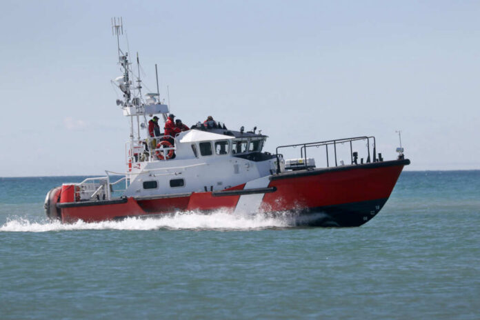 Red and white coast guard boat on ocean water