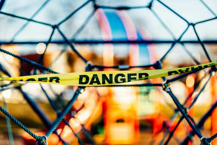 Danger tape on playground equipment structure.