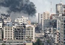 City buildings with heavy smoke and extensive war damage