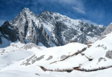 Snowy mountain landscape with wooden walking paths tourists