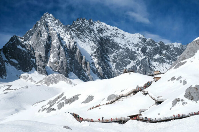 Snowy mountain landscape with wooden walking paths tourists