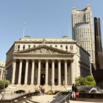 Neoclassical courthouse with tall columns and nearby modern tower