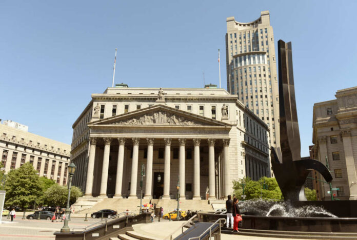 Neoclassical courthouse with tall columns and nearby modern tower