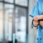 Foreign Doctors BLOCKED—Rural Hospitals in Crisis Healthcare professional holding a stethoscope in hospital