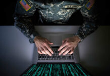 Cheap Phone Data Targets U.S. Bases A soldier in U.S. Army uniform typing on a laptop with green code displayed on the screen