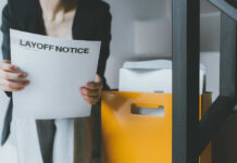 Person holding a layoff notice in an office setting