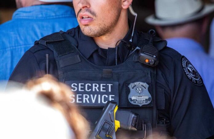 A Secret Service officer in tactical gear with a radio and firearm