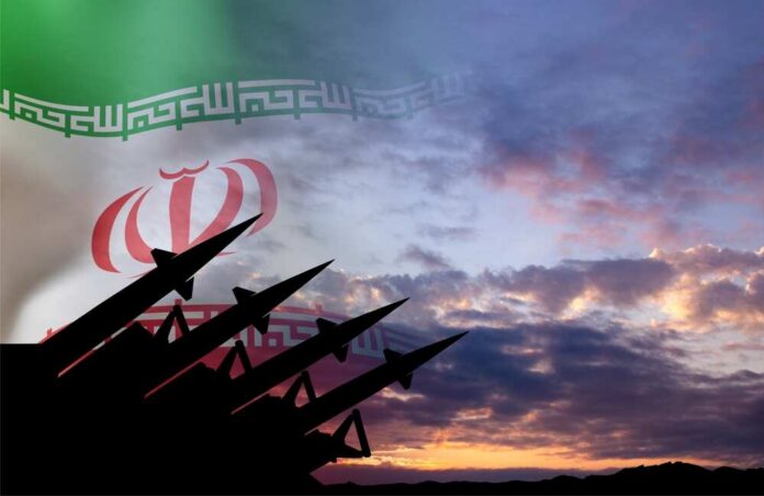 Silhouette of missiles in front of the Iranian flag during sunset