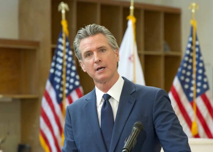 A government official speaking at a podium with American flags in the background
