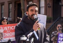 Man speaking into a microphone at a protest for senior justice