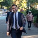 Mamdani Defends NYPD Amid ICE Protest Clash A man in a suit walking happily in a city park