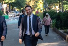 A man in a suit walking happily in a city park