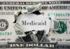 A torn dollar bill revealing the word 'Medicaid'