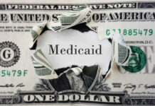 A torn dollar bill revealing the word 'Medicaid'