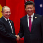 Two international leaders shaking hands at a diplomatic event