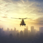 Drug Boat Downed — Where’s The Paper Trail? Silhouette of a helicopter flying over a city skyline at sunset