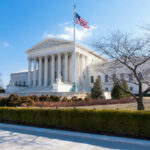 United States Supreme Court building with flag and columns