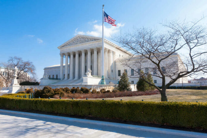 United States Supreme Court building with flag and columns