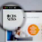 CBS News website viewed through a magnifying glass.