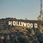 Hollywood sign with communication tower on hillside.