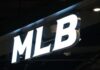 Florida AG Targets MLB Over Bible Hats Illuminated MLB sign on a dark ceiling