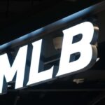 Florida AG Targets MLB Over Bible Hats Illuminated MLB sign on a dark ceiling