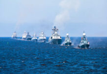 A fleet of warships sailing in formation on the ocean