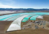 Aerial view of turquoise evaporation ponds and industrial site in a desert basin