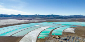Aerial view of turquoise evaporation ponds and industrial site in a desert basin
