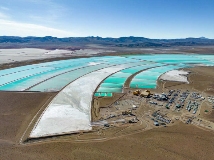 Aerial view of turquoise evaporation ponds and industrial site in a desert basin