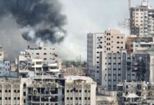 Intel Claims Collide With Shattered Wards A view of destroyed buildings with smoke rising in the background