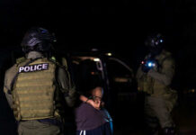 Viral Courthouse Arrest Sparks Records Blackout Two armed officers detaining person at night