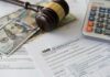 Tax forms with a gavel, cash, and a calculator