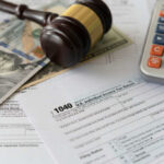 Federal Judge Probes Collusive Tax Truce Tax forms with a gavel, cash, and a calculator