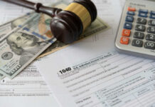 Tax forms with a gavel, cash, and a calculator