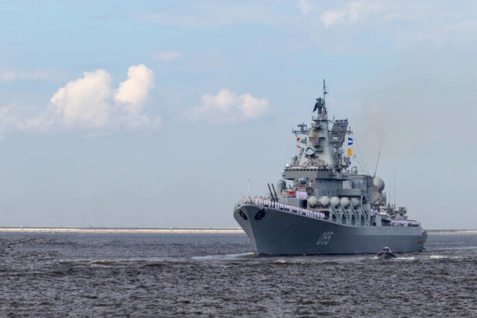 Large gray naval warship sailing on open water