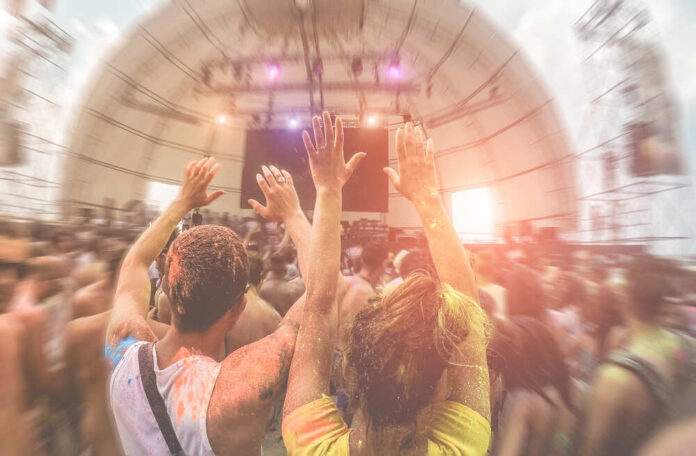 Happy,Friends,Having,Fun,In,Color,Dust,Concert,Festival,Outdoor Crowd at a music festival with hands raised in celebration
