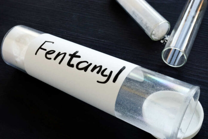 A glass container labeled 'Fentanyl' with a white powder inside