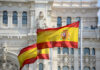 Holy Wildcard: Pope Picks Cells Over Palaces Two Spanish flags waving in front of a historic building