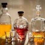 Moderate Drinking’s NASTY Catch A collection of decorative liquor bottles and shot glasses on a table
