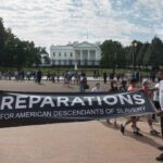 Pressley’s Bold Pitch, No Payout Plan Two individuals holding a banner for reparations in front of the White House