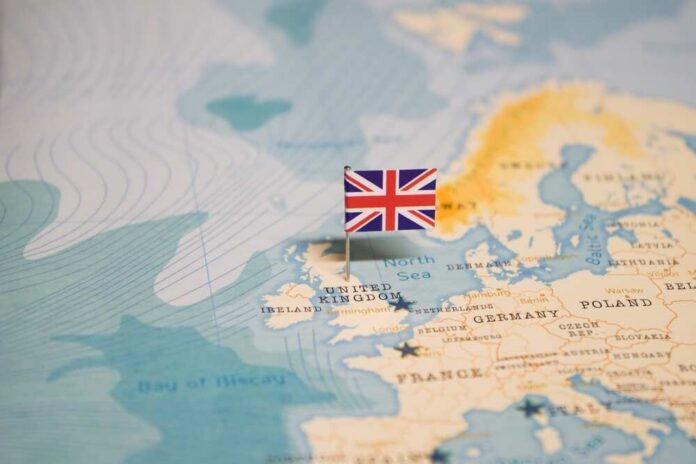 The,Flag,Of,United,Kingdom,On,The,World,Map. Map highlighting the United Kingdom with a flag