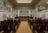 Scotland’s Two-Tier Justice Exposed Interior view of a courtroom with wooden benches and large murals