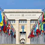 United Nations building with numerous national flags outside.