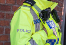 Police officer in high-visibility jacket with body camera